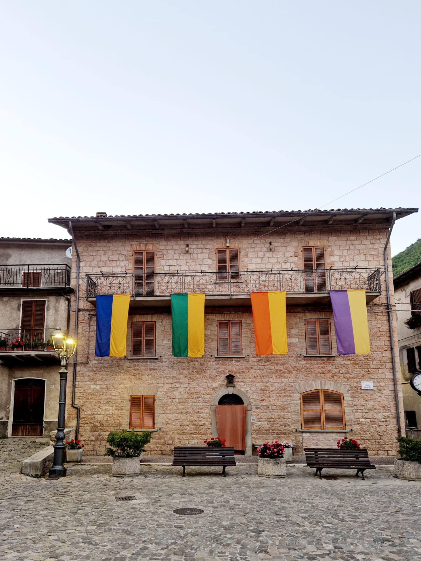 Le quattro bandiere colorate dei cantoni sulla facciata di un palazzo di Pianello