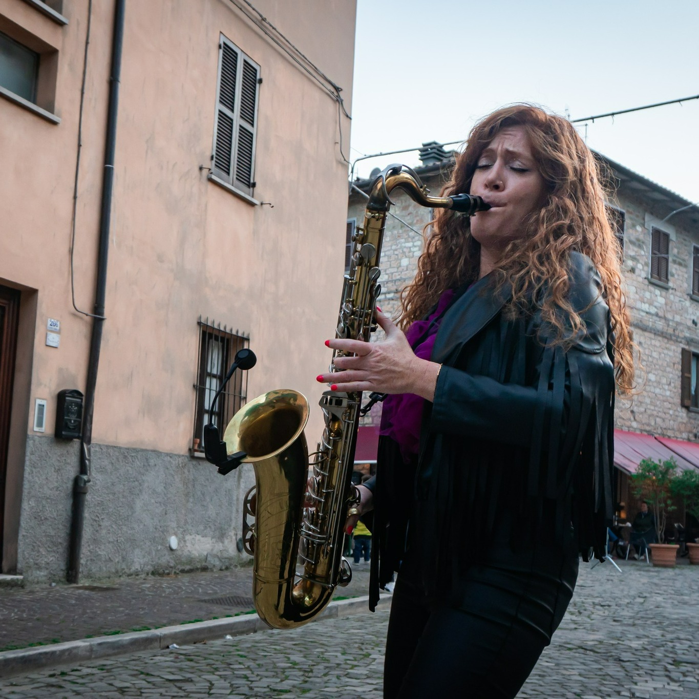 Musicista suona il sassofono nelle vie di Pianello