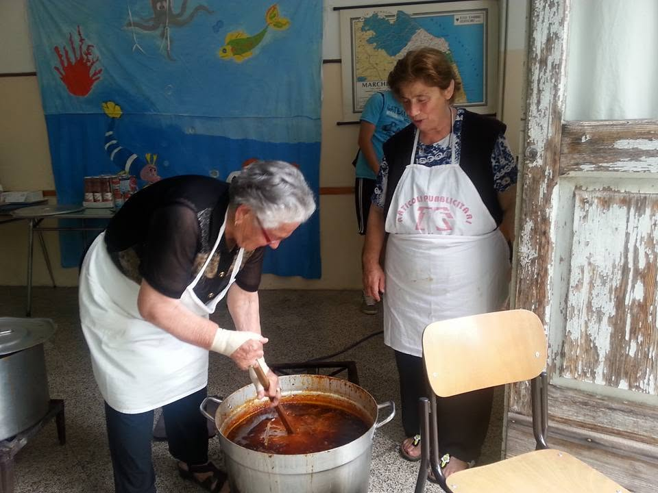 Due donne preparano il sugo in una grande pentola, tramandando la tradizione di Pianello