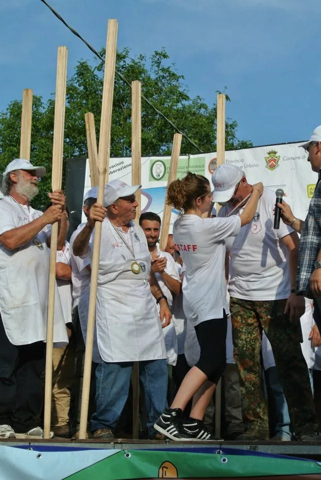 Una volontaria consegna una medaglia a un membro della squadra